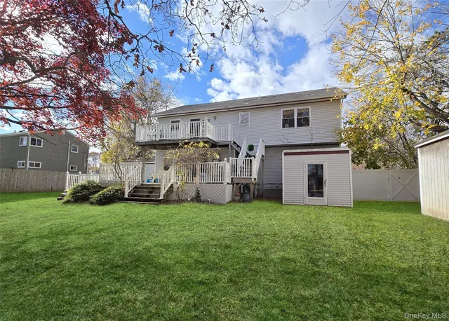 a view of a white house with a big yard and large trees