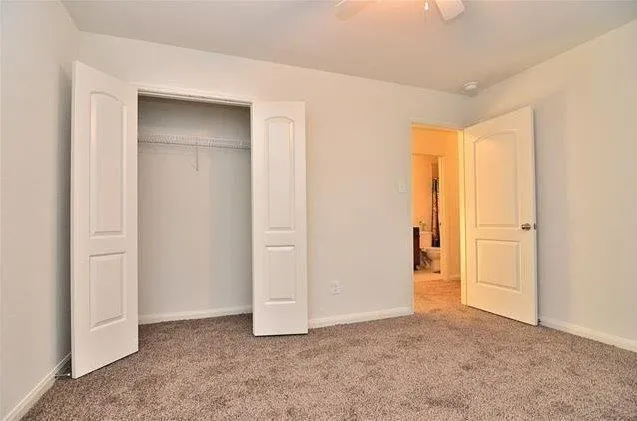 an empty room with a wooden floor and windows