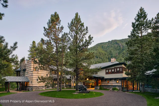 a view of a big house with a big yard and large trees
