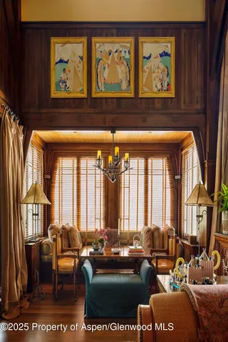 a living room with furniture two large windows