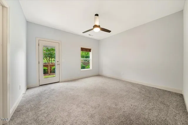 an empty room with windows and ceiling fan