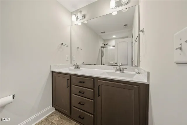 a bathroom with a double vanity sink and mirror