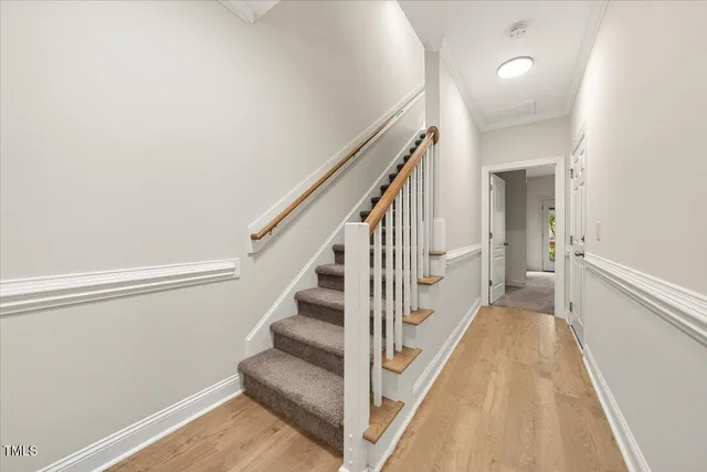 a view of a hallway with wooden floor and staircase