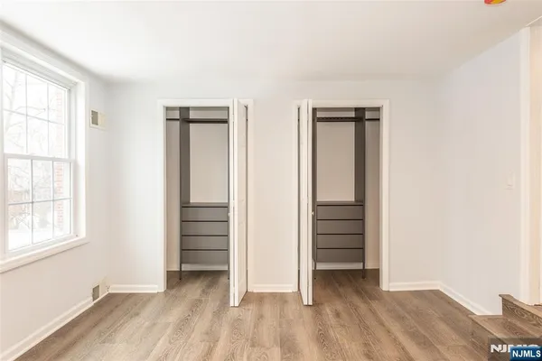 an empty room with closet and windows
