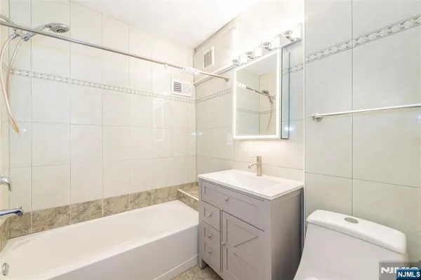 a bathroom with a sink toilet vanity and shower