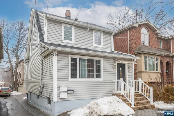 a front view of a house with a tree