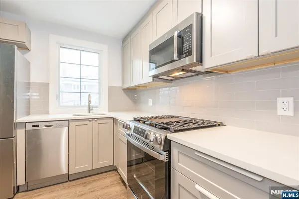 a kitchen with granite countertop a stove top oven microwave and cabinets