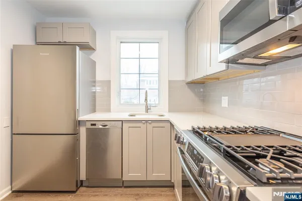 a kitchen with a stove a refrigerator and a window