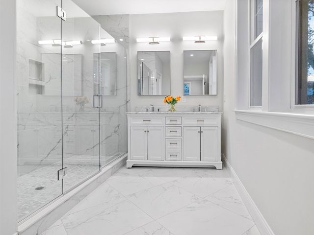 a spacious bathroom with a shower a sink and mirror