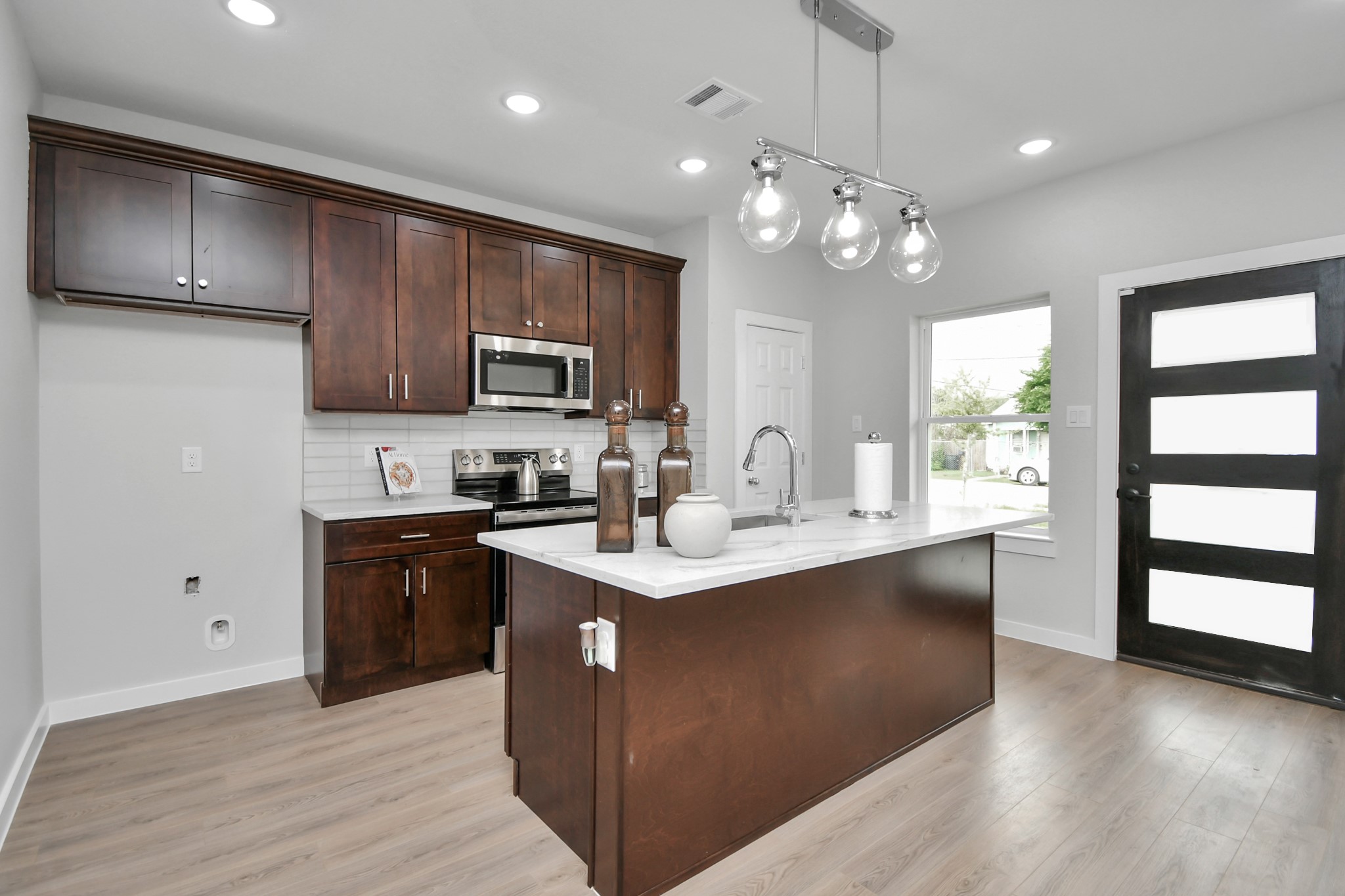 9808 Nedwald Street Houston, TX 77029 - Photo 12 of 39 a kitchen with cabinets a sink stainless steel appliances and window