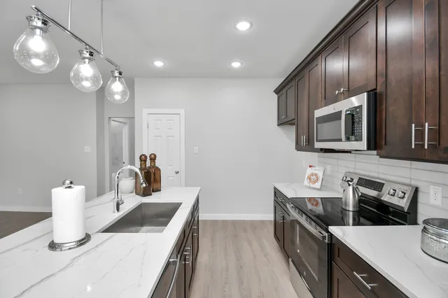 a kitchen with stainless steel appliances a sink stove and microwave