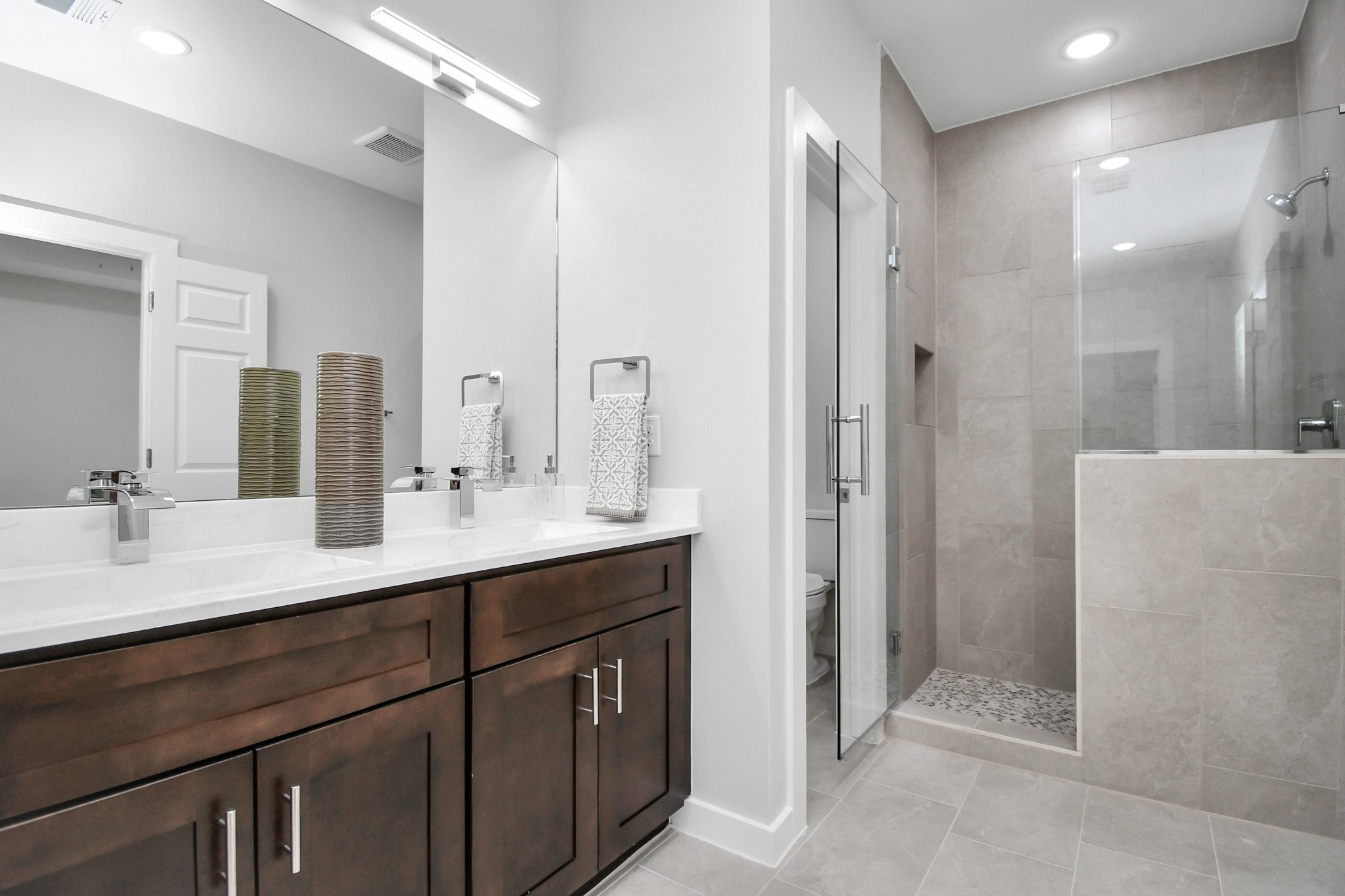 9808 Nedwald Street Houston, TX 77029 - Photo 32 of 39 a bathroom with a double vanity sink mirror and shower