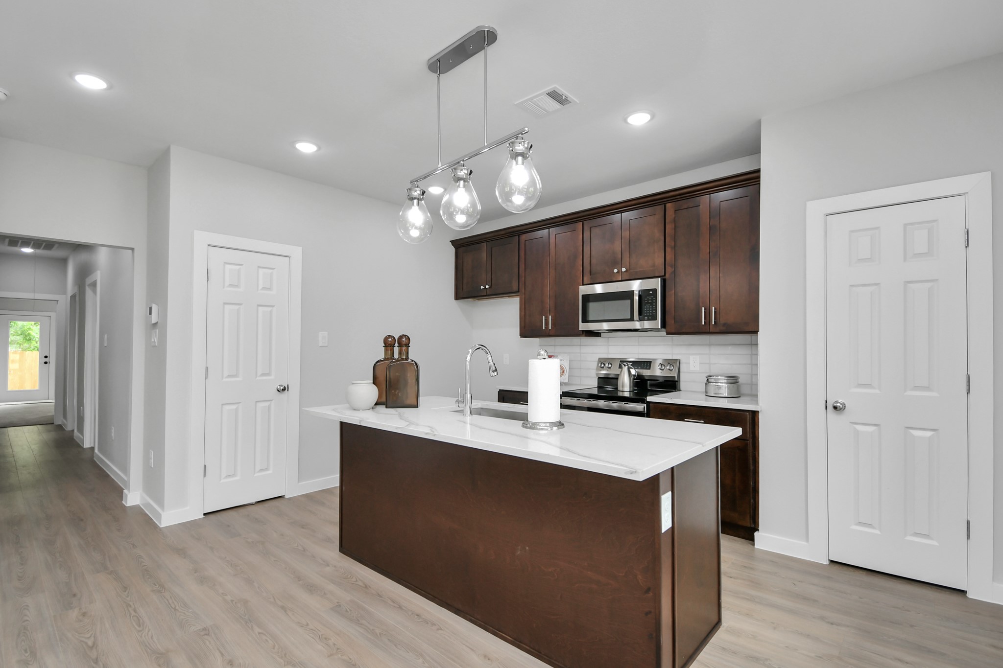 9808 Nedwald Street Houston, TX 77029 - Photo 10 of 39 a kitchen with kitchen island granite countertop stainless steel appliances a sink cabinets and wooden floor