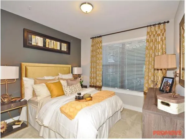 a bedroom with a bed a couch and large window