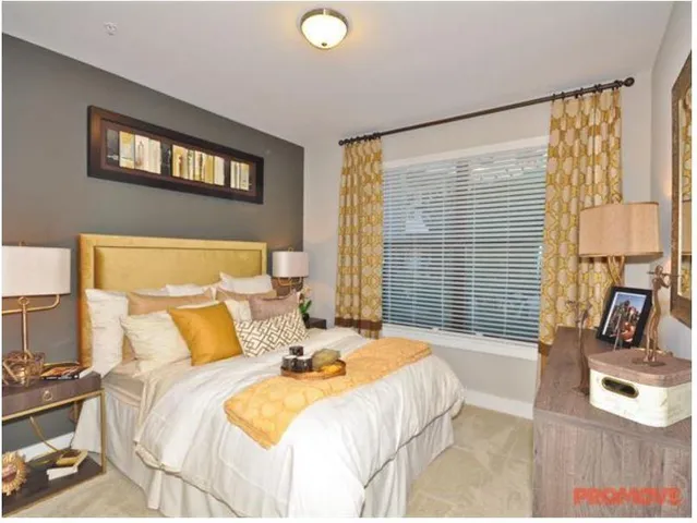 a bedroom with a bed a couch and large window