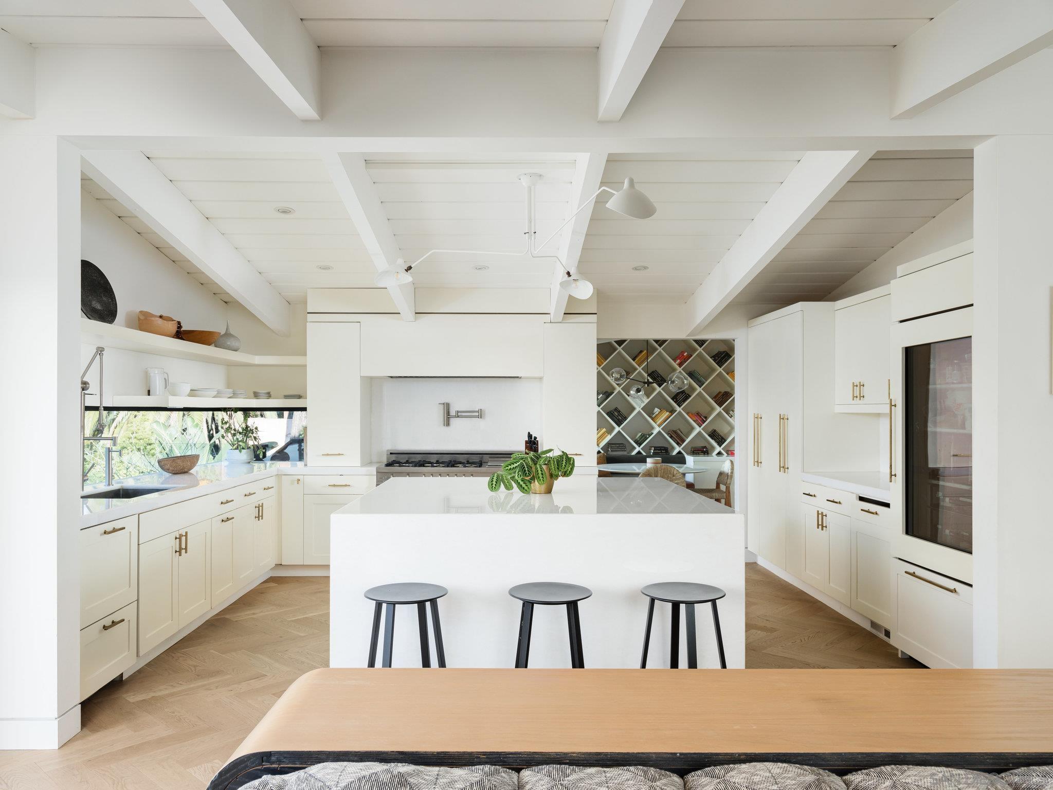 a kitchen with kitchen island a stove a refrigerator and a dining table with wooden floor