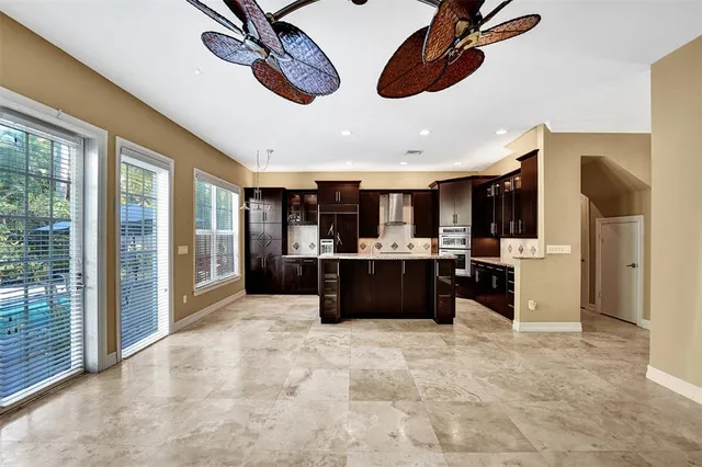 a kitchen with stainless steel appliances kitchen island granite countertop a refrigerator and a sink