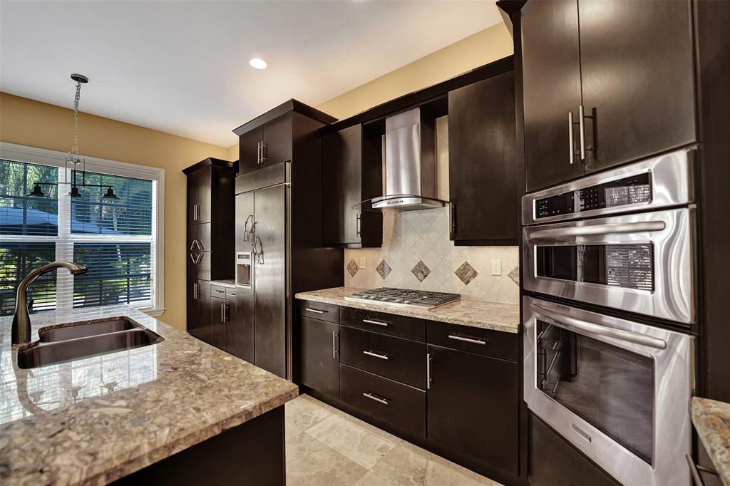 101 Northeast 21st Street Wilton Manors, FL 33305 - Photo 16 of 70 a kitchen with granite countertop stainless steel appliances and wooden cabinets