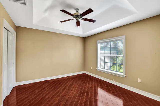 a view of a livingroom with wooden floor and a ceiling fan