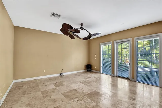 a living room with furniture ceiling fan and a large window