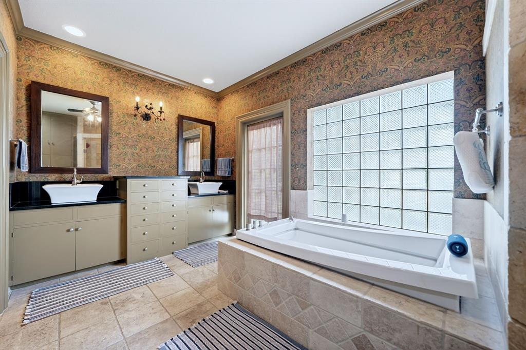 1901 Rose Pointe Athens, TX 75752 - Photo 17 of 37 Soaking tub with tile surround, glass block window, dual vanity with vessel sinks, built-in cabinetry, and tile flooring