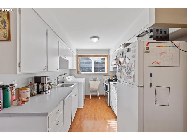 a kitchen with a refrigerator and white cabinets