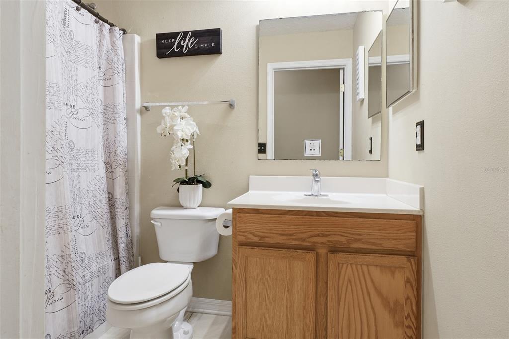2120 Nicollett Way Leesburg, FL 34748 - Photo 15 of 22 a bathroom with a granite countertop sink a toilet and a mirror