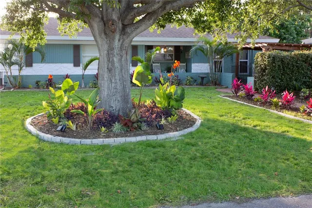 a front view of a house with a yard and potted plants