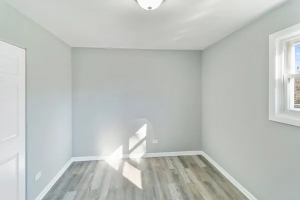a view of empty room with wooden floor