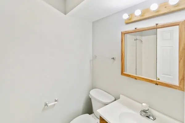 a bathroom with a toilet sink and mirror