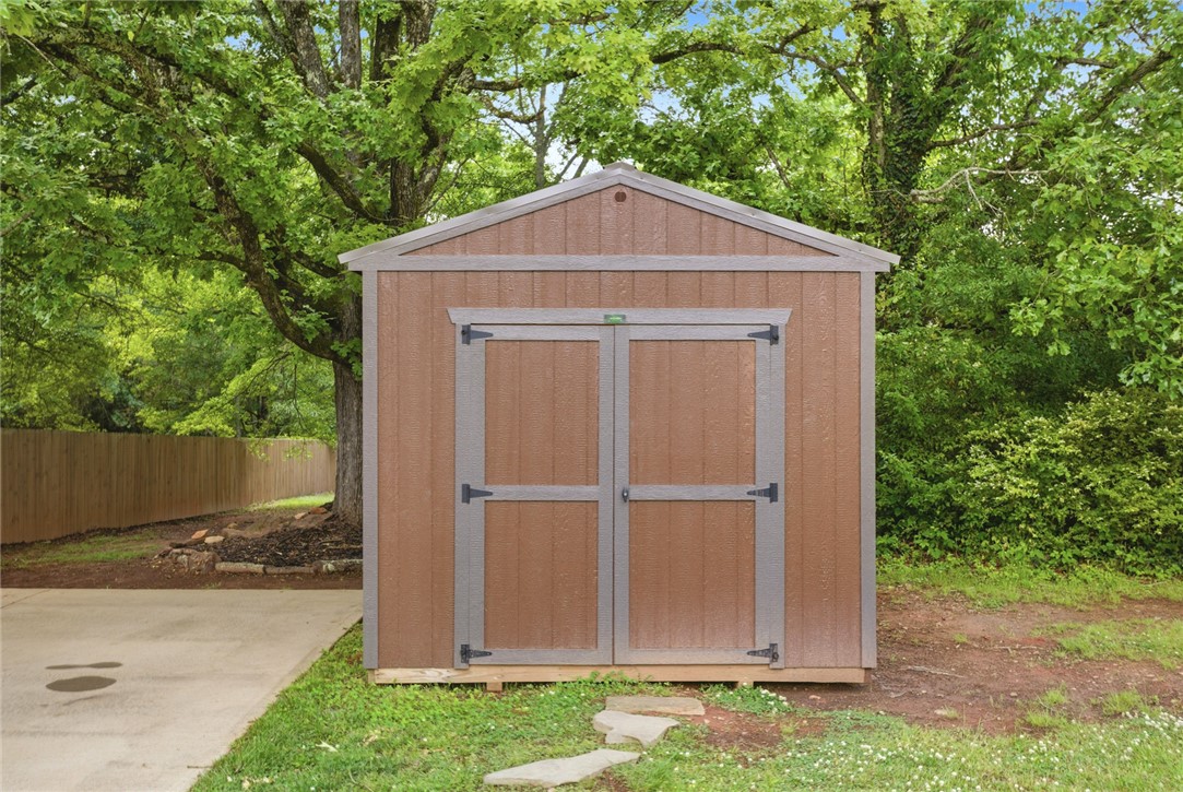 119 Fruit Mountain Road Easley, SC 29640 - Photo 30 of 31 This outdoor shed offers practical storage solutions within a lush, green environment.