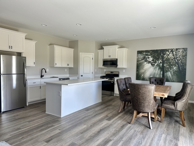 1323 Sioux Turn Kankakee, IL 60901 - Photo 5 of 15 a kitchen with a table chairs refrigerator and cabinets