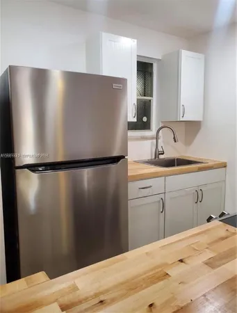 a kitchen with a refrigerator and a sink