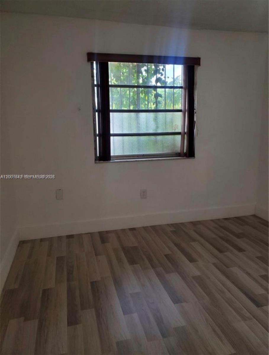 3181 Southwest 13th Street, Unit 108 Miami, FL 33145 - Photo 6 of 10 a view of wooden floor and windows in a room