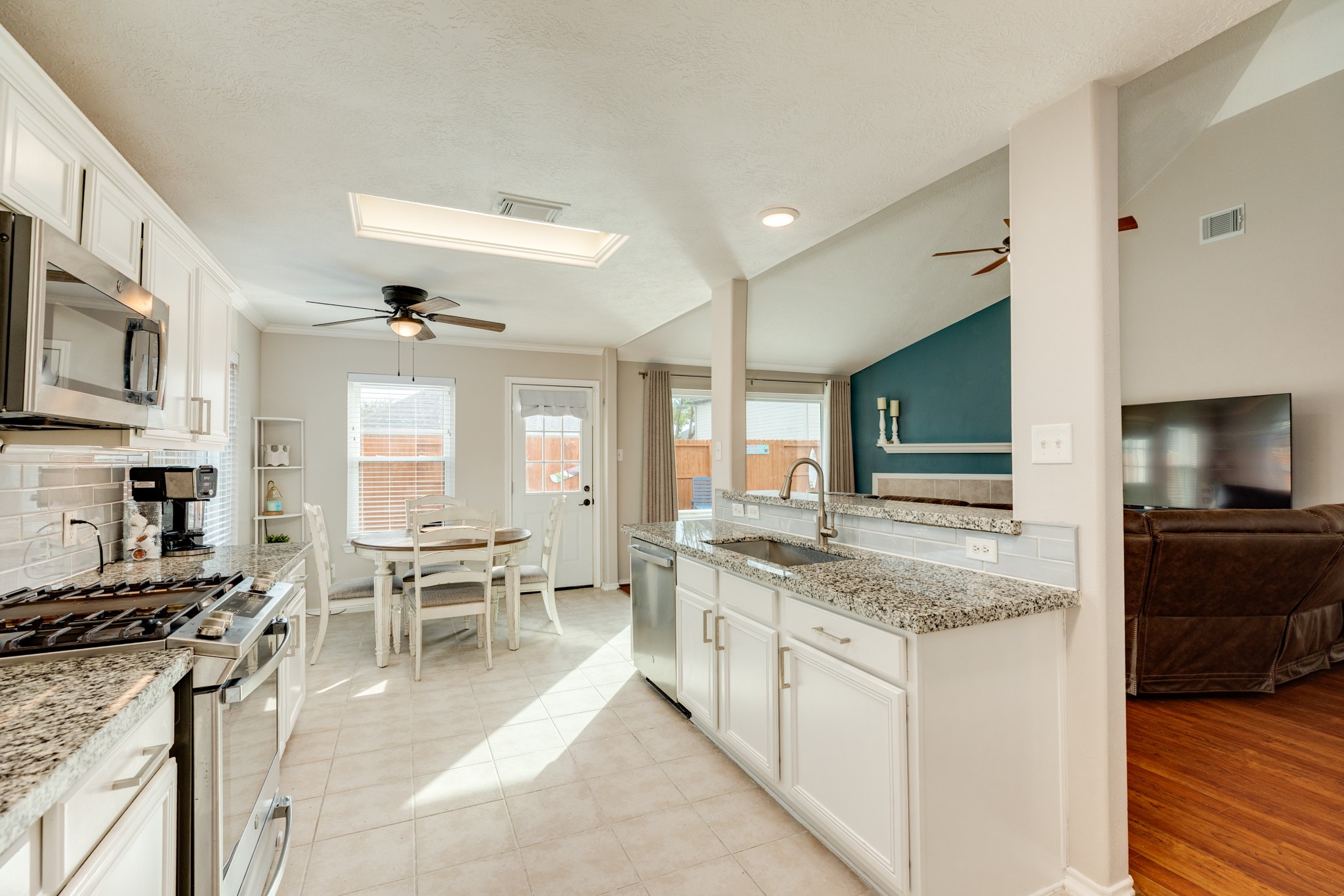 4113 Merlet Drive Pearland, TX 77584 - Photo 13 of 36 This view highlights the tile flooring, expansive open space, and abundant natural light streaming through the windows.