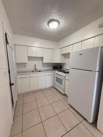 a kitchen with white cabinets and white stainless steel appliances