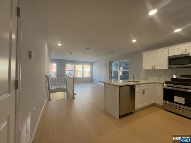 a kitchen with granite countertop a stove top oven sink and cabinets
