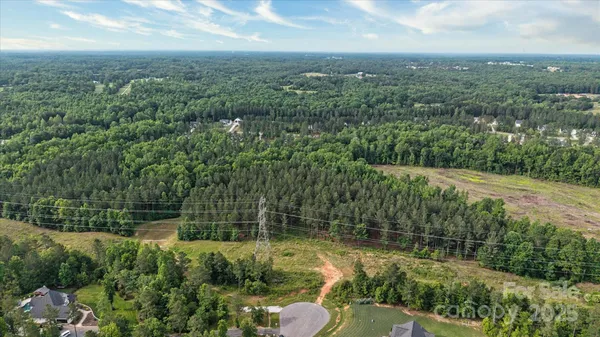 an aerial view of residential houses with outdoor space and trees