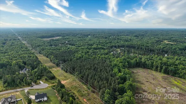 an aerial view of residential houses with outdoor space and trees