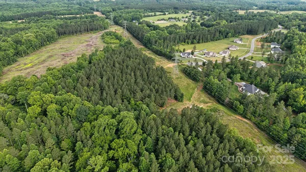 an aerial view of residential houses with outdoor space and trees