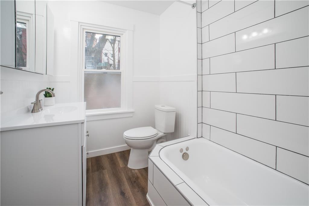 85 Pasadena Street Pittsburgh, PA 15211 - Photo 21 of 25 a bathroom with a toilet a sink a mirror and vanity