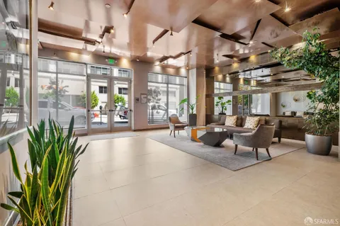 a lobby with furniture and potted plants