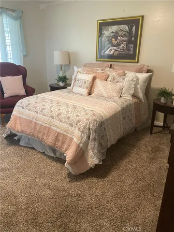 a large bed sitting in a bedroom next to a window