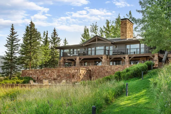 a view of a big house with a big yard and potted plants