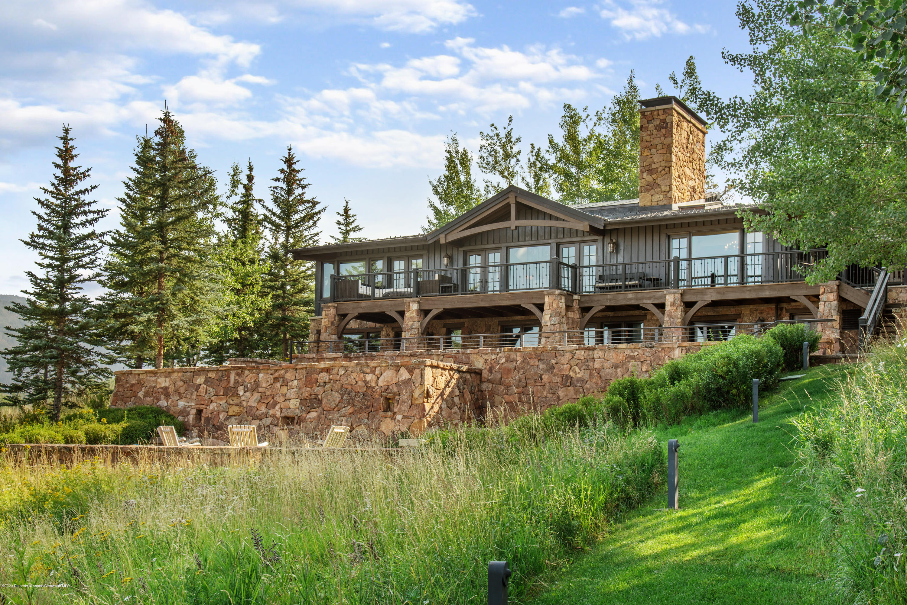 565 North Starwood Road Aspen, CO 81612 - Photo 2 of 50 a view of a big house with a big yard and potted plants