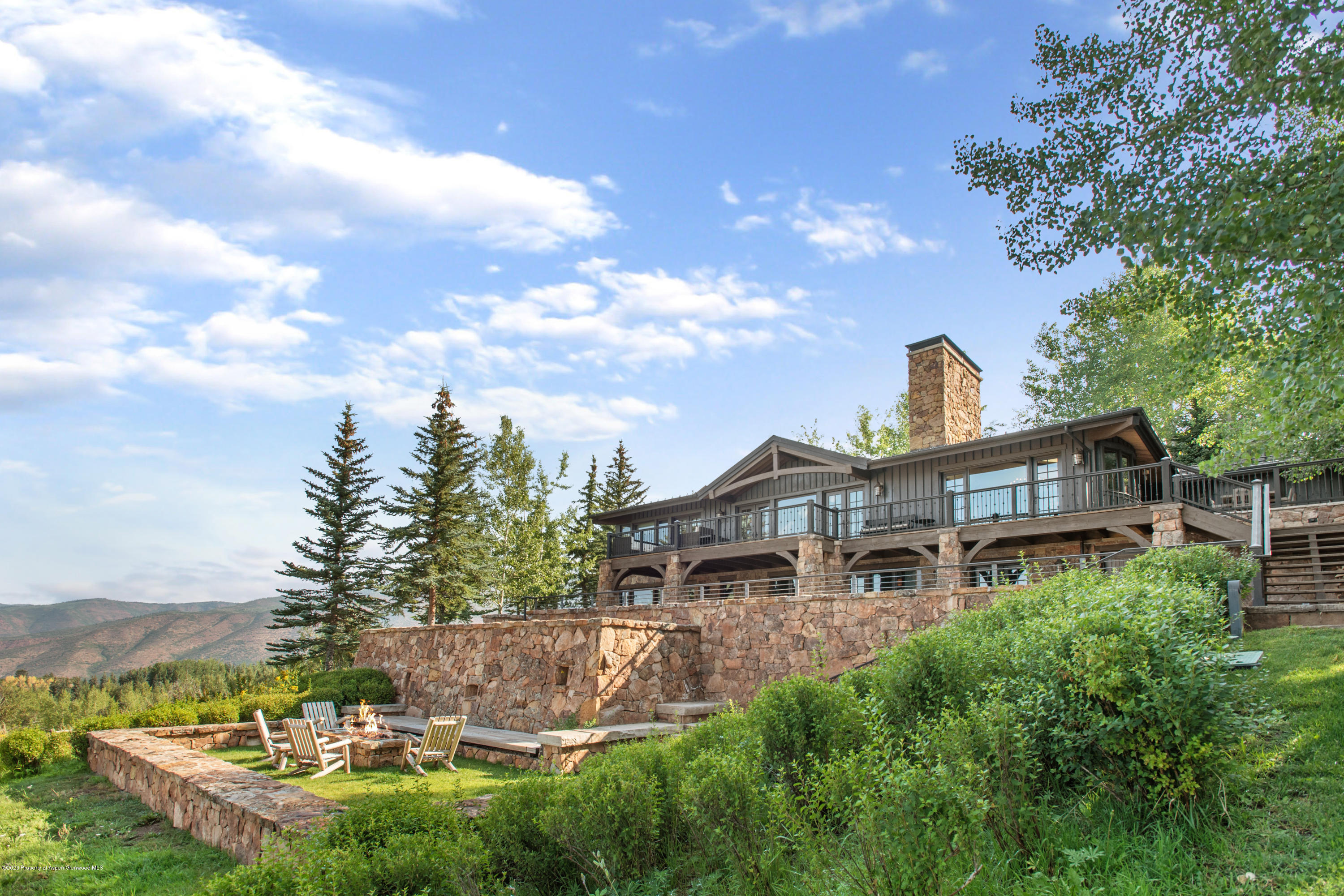 565 North Starwood Road Aspen, CO 81612 - Photo 27 of 50 a front view of a house with a yard fountain and large tree