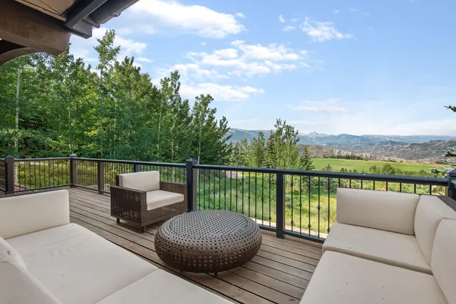 a view of a lush green mountain with a mountain in the background