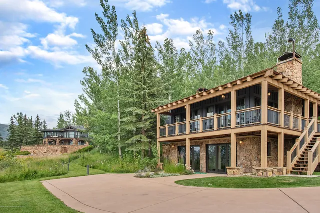 a dining room with furniture a fireplace and large windows