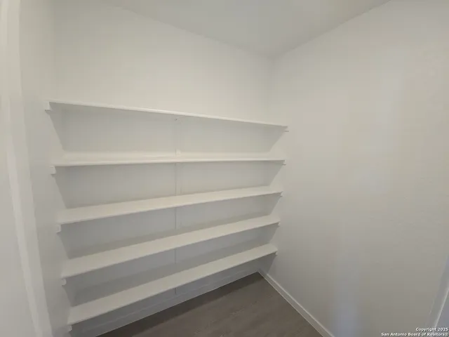 a view of walk in closet with empty racks