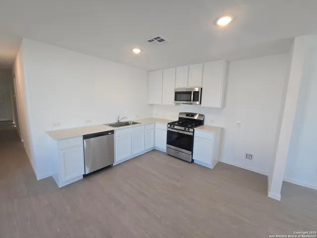a large kitchen with cabinets and stainless steel appliances
